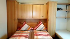 メーデバッハにあるFerienwohnung Haus Weitblickの小さなベッドルーム(ベッド2台、木製キャビネット付)