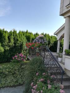 a wrought iron staircase with flowers in a garden at Vila Sentić in Vranje