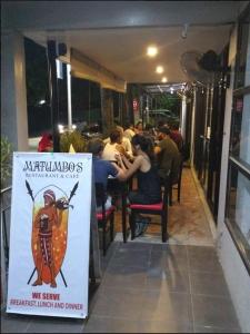 a group of people sitting at a table in a restaurant at Hidden Hill Hotel in Mactan