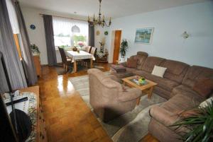 ein Wohnzimmer mit einem Sofa und einem Tisch in der Unterkunft Haus Rehblick FeWo-EG-1 in Sankt Andreasberg