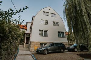 a house with a car parked in front of it at Villa Paula in Polanica-Zdrój