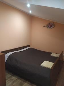 um quarto com uma cama preta num quarto em Садиба у Богдана em Skole