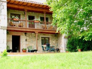 ein Haus mit einer Terrasse mit Stühlen und Tischen in der Unterkunft El Pedroso de Llanes in Villahormes