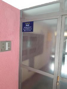 a door with a sign on it next to a pink wall at Apartman Katedrala in Sarajevo