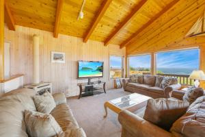 a living room with a couch and a tv at Sandborn in Fort Bragg
