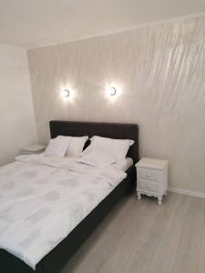 a bedroom with a large bed with white sheets at White studio in Cluj-Napoca