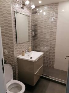 a bathroom with a toilet and a sink and a shower at White studio in Cluj-Napoca