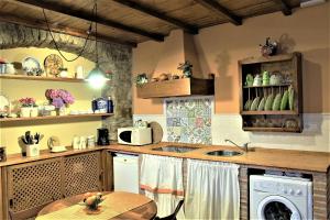 a kitchen with a sink and a washing machine at Cau La Mar in Lastres