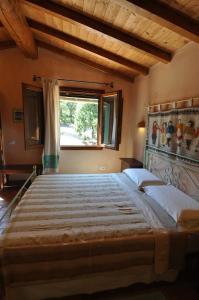uma cama grande num quarto com uma janela em La Suara Tolta em San Pantaleo