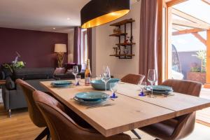 uma mesa de madeira com cadeiras e uma sala de jantar em Le Panoramic & Spa em Itterswiller