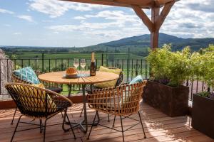 een terras met een tafel en stoelen bij Le Panoramic & Spa in Itterswiller