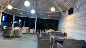 an empty patio with tables and chairs and lights at Bobo Bungalow in Nusa Lembongan