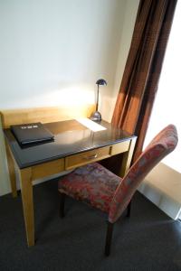 a chair and a lamp in a room at Noah's Mid City Motor Inn Muswellbrook in Muswellbrook