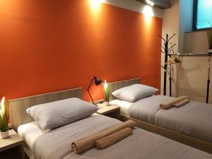 Duas camas num quarto com paredes cor de laranja em Centralcityrooms em Ljubljana