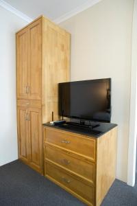 a small tv sitting on top of a wooden stand at Noah's Mid City Motor Inn Muswellbrook in Muswellbrook
