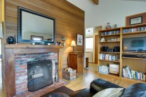 a living room with a fireplace with a television above it at Chapman Cottage in Cannon Beach