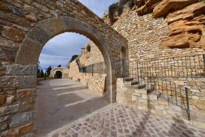 una pared de piedra con un arco en un edificio en La Conquesta de Culla, en Culla