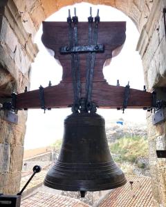 a large bell in a tower with a cross at La Conquesta de Culla in Culla