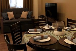 sala de estar con mesa con sillas y sofá en Bristle Ridge Residences - Oakhill, en Baguio