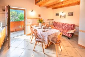 a dining room with a table and a couch at Appartamenti Casavacanzepejo in Cogolo