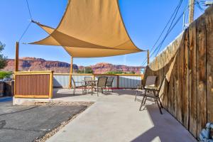 un patio con sillas y una gran sombrilla amarilla en Bella Casa - Loft, en Moab