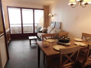 a living room with a table and a couch at Les Terrasses d Azur in Isola 2000