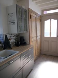 eine Küche mit einem Waschbecken und eine Tür zu einem Zimmer in der Unterkunft Mini Tribu de Beauval 2ch Saint Aignan jardin et parking privé in Saint-Aignan