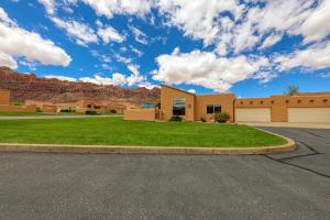 a house with a green lawn in front at Rim Village T2 in Moab