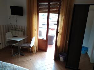 una camera con scrivania e tavolo e una porta con finestra di Casa Celeste a Roma