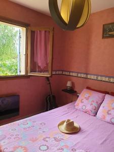 um chapéu numa cama num quarto com uma janela em Villa à la campagne em Camélas