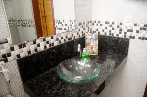 lavabo en el baño con un tazón de cristal verde en Cardeiro Flat-S.M.Gostoso, en São Miguel do Gostoso