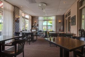 a dining room with tables and chairs and windows at HCR Prinsen in Haarlo