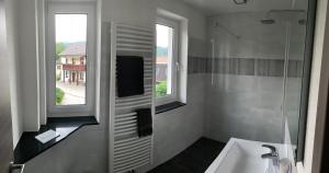 a bathroom with a sink and a mirror and two windows at Ferienwohnung Herold in Olbernhau