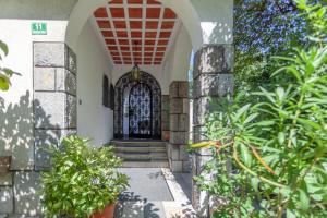 una entrada a un edificio con un arco y plantas en Villa Magnolia en Liubliana