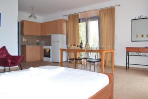 una camera con letto e una cucina con tavolo di Maistrali a Vassiliki
