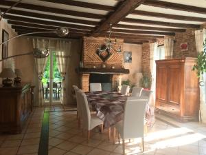 a dining room with a table and chairs and a fireplace at Chambres d'Hôtes Au Clos Saint Georges in Saint-Jory