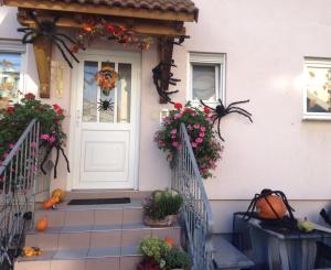 eine Haustür eines Hauses mit Kürbissen und Blumen in der Unterkunft Ferienwohnung am Europapark - klimatisiert in Rust