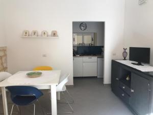 a kitchen with a white table and a desk with chairs at Casa Tancredi in Scicli