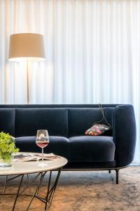 a blue couch sitting in a living room with a table at Mintrops Land Hotel Burgaltendorf in Essen