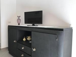 a black cabinet with a tv on top of it at Casa Tancredi in Scicli