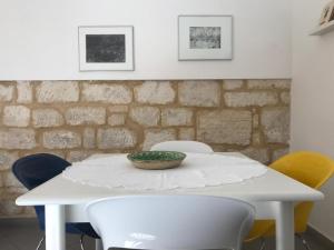 un tavolo bianco con sedie e una ciotola sopra di Casa Tancredi a Scicli