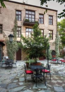 patio ze stołami i krzesłami przed budynkiem w obiekcie Boutique Hotel Palea Poli w mieście Nausa