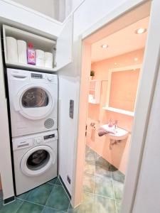 eine Waschküche mit einer Waschmaschine und einem Waschbecken in der Unterkunft Lovely-Flats "Gasteiner" in Berlin
