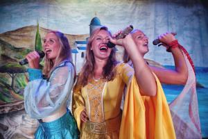 a group of three women singing into microphones at Sotavento Beach Club in Costa Calma