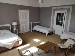 sypialnia z 2 łóżkami, stołem i krzesłami w obiekcie Manoir le Mingreaud Chambres d'hôtes w mieście Sainte-Gemme-la-Plaine