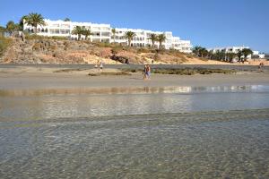 a group of people walking on the beach at Sotavento Beach Club in Costa Calma