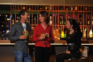 Ein Mann und zwei Frauen stehen vor einer Bar in der Unterkunft Sotavento Beach Club in Costa Calma