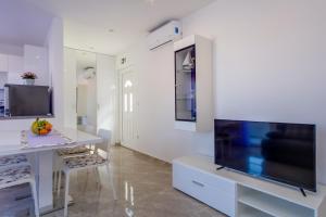 uma sala de estar com uma grande televisão de ecrã plano em Apartmani Beatrice em Mali Lošinj