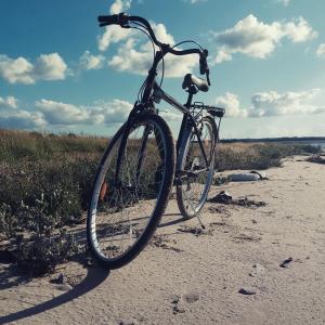 een fiets geparkeerd op een strand op het zand bij Les Sauges in Isigny-sur-Mer