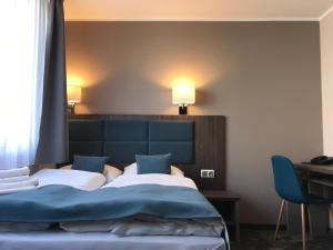 een slaapkamer met een bed, een bureau en 2 lampen bij Hotel Sleep Wrocław in Wrocław